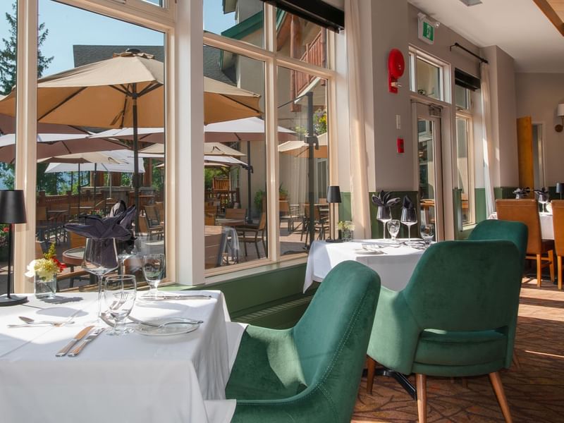 Hotel restaurant with dining table, chairs and patio