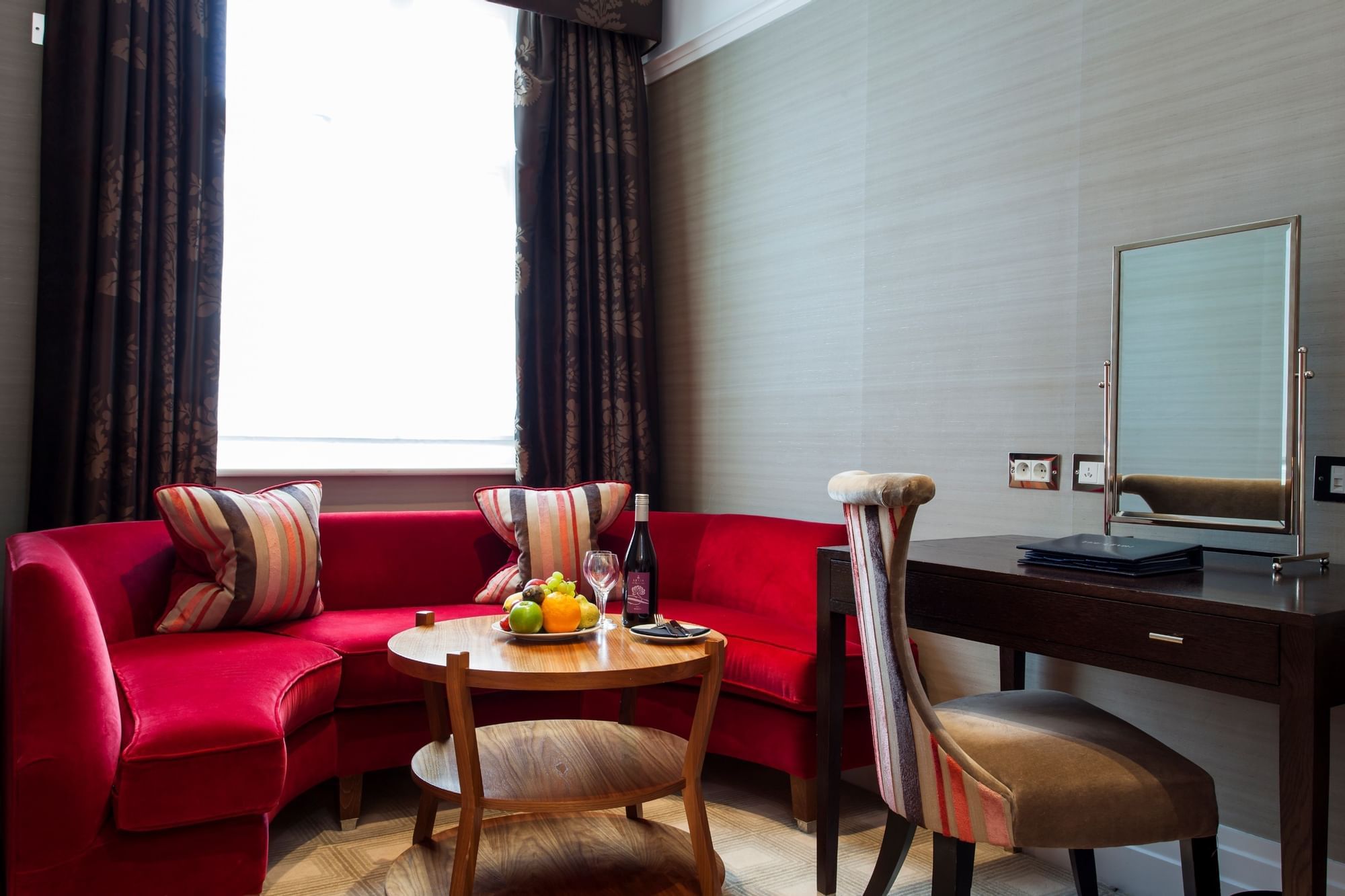 Comfy curved lounge area by a desk in a Room at The Capital Hotel, Apartments & Townhouse - London