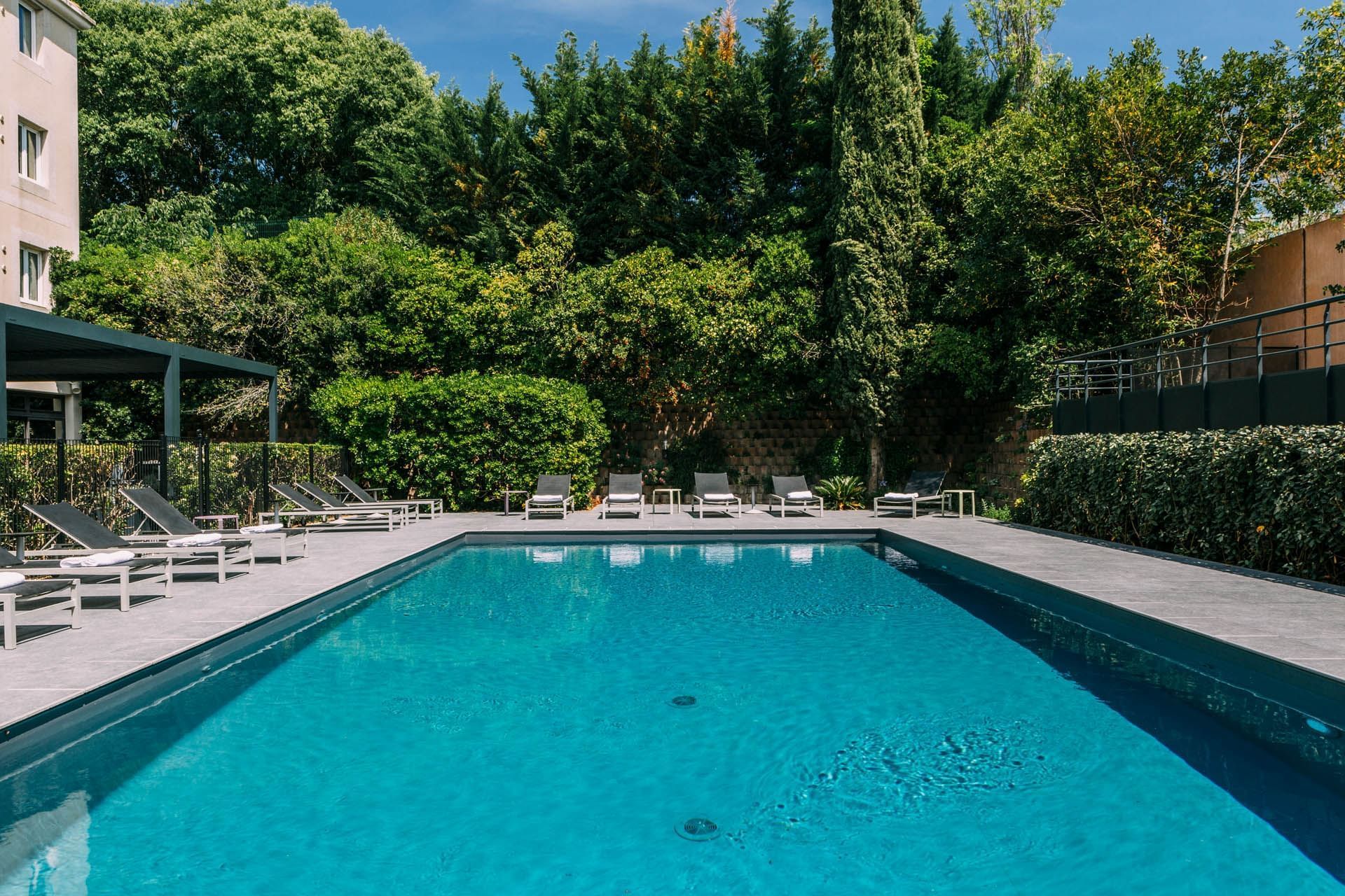 Piscine avec chaises longues à Escale Oceania Aix-en-Provence