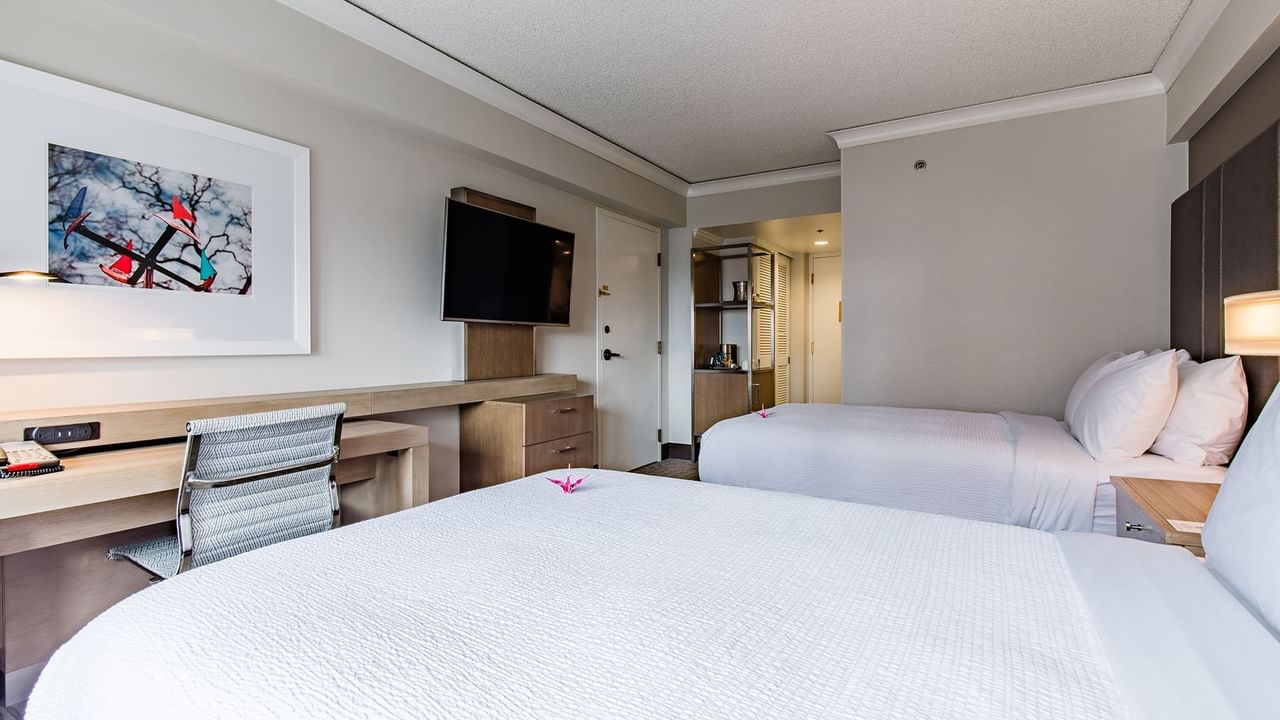 Hotel guestroom with two beds, TV and desk