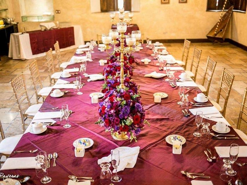 Table arrangement with floral decorations in Meson del Obispo at Porta Hotel Antigua