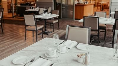 Garden Room featuring elegant table settings with white cups & plates at Spencer Hotel, offering fine dining London Ontario 