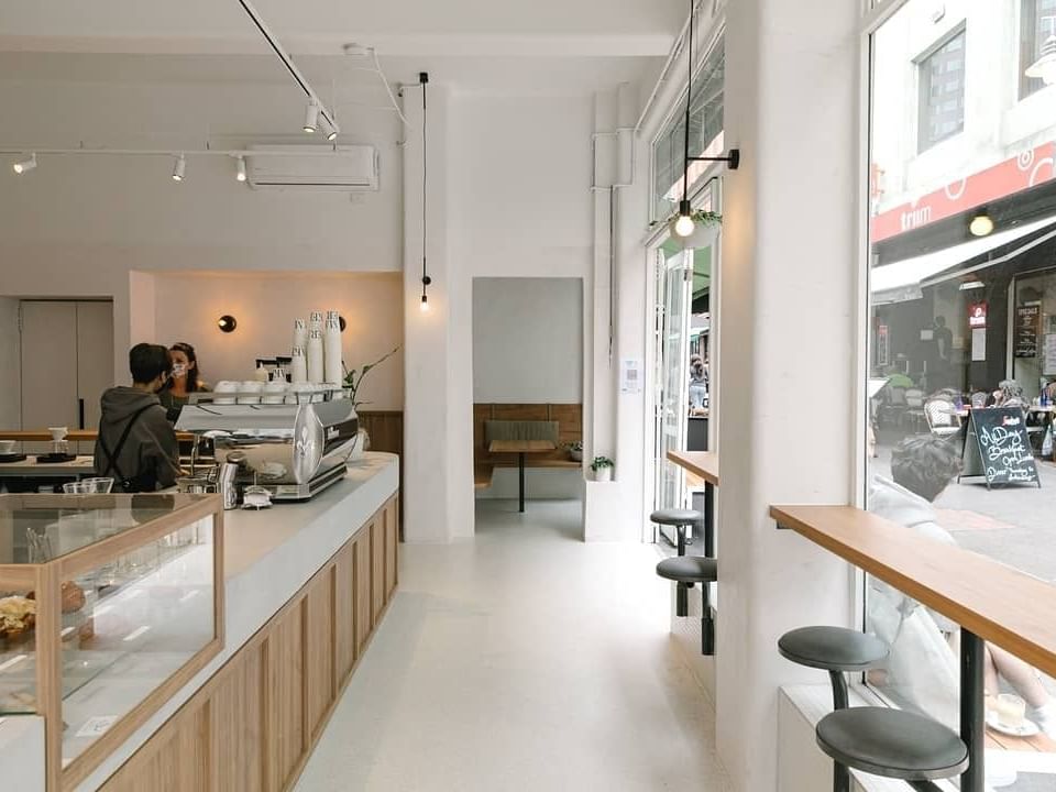 Cafe with bench seating along the window and counter with coffee machine