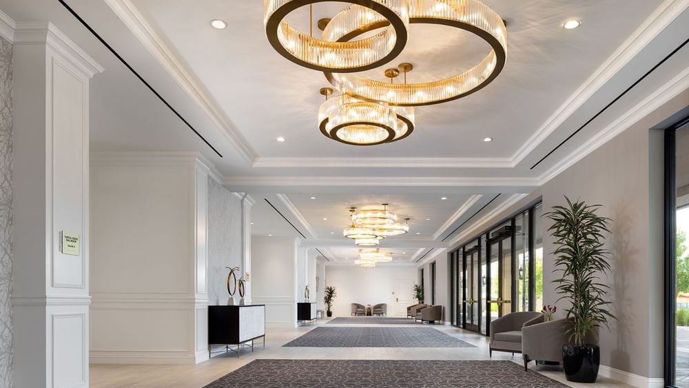 Elegant foyer with large circular chandeliers at Warwick Melrose in Dallas.