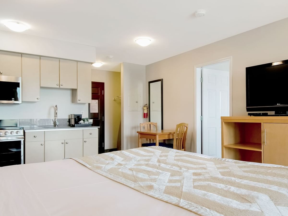 One-bedroom suite with a kitchenette, dining area and TV.