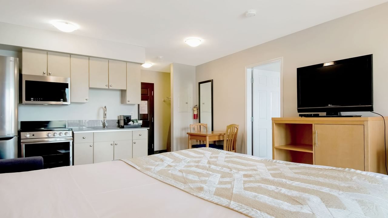 One-bedroom suite with a kitchenette, dining area and TV.