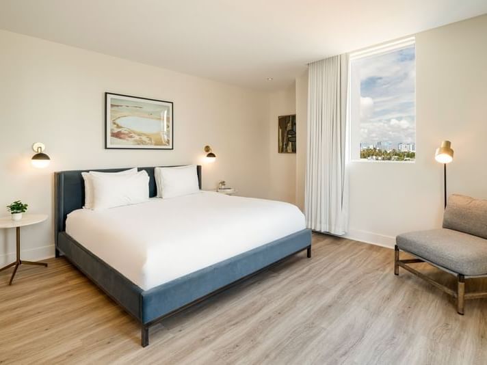 Deluxe King Balcony with a cozy bed and large city view window at Kenmore Village Hotel, among the best South Beach hotels