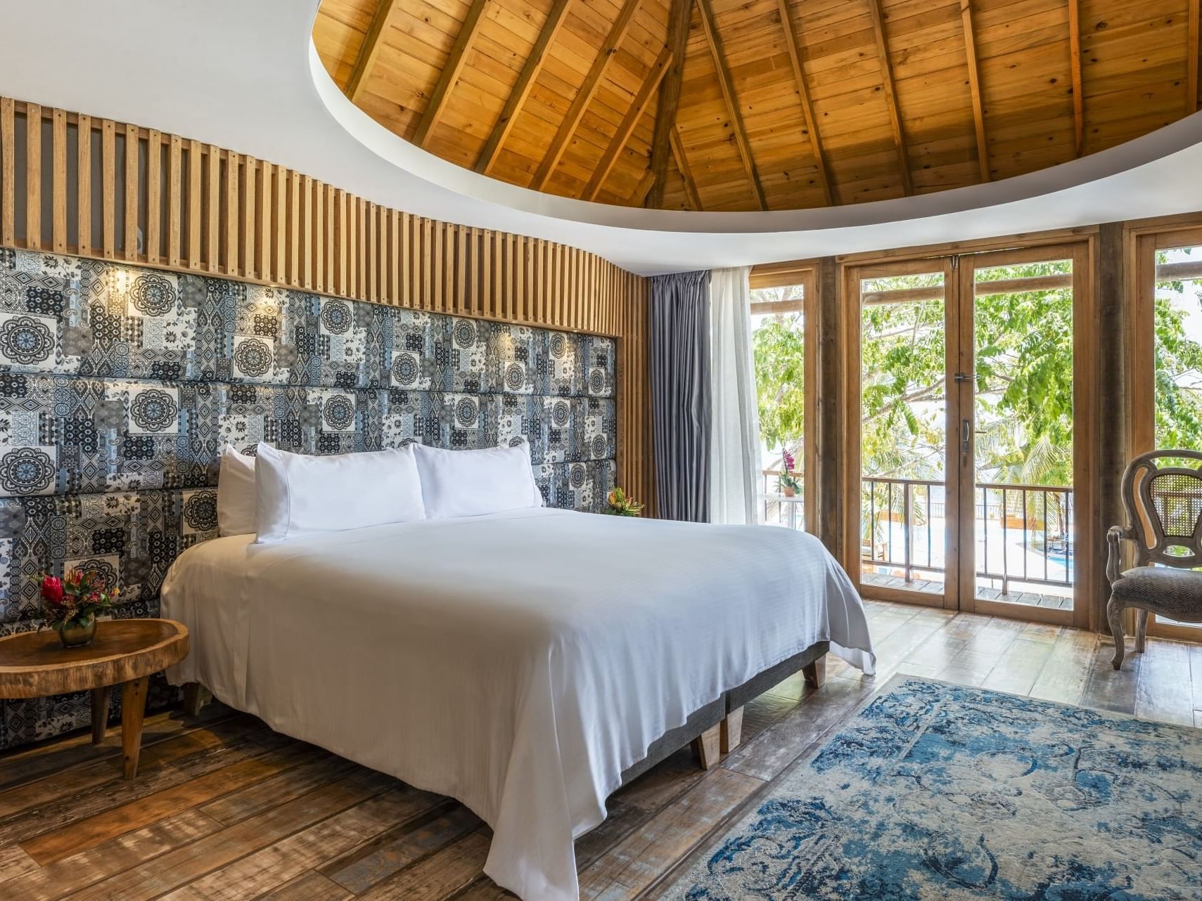 Comfy bed with side tables and outdoor view in Master Suite at Hotel Isla Del Encanto