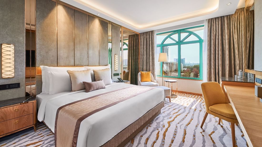 King bed with a single sofa by the balcony in Deluxe Room at Sunway Hotels & Resorts