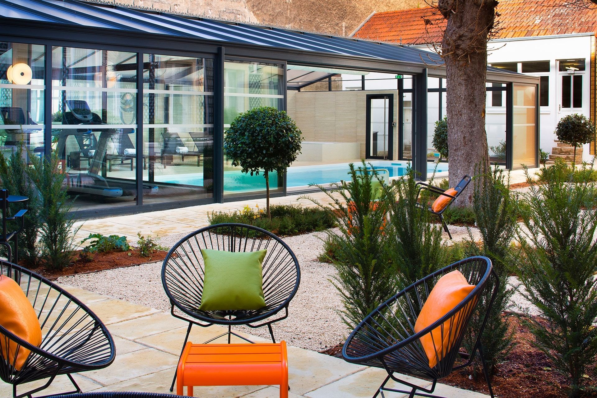 Espace extérieur avec sièges près de la piscine à l'Oceania Le Jura Dijon