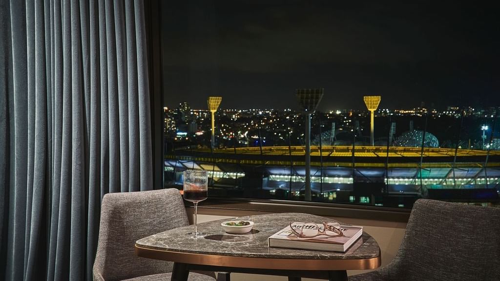 Deluxe Executive Suite with seating area and nighttime stadium views at Pullman East Melbourne