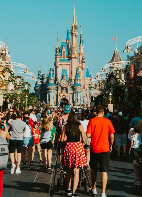 A crowd of people moving toward Cinderella's Castle at Magic Kingdom. Read our guide for tips on navigating Disney theme parks as an introvert.