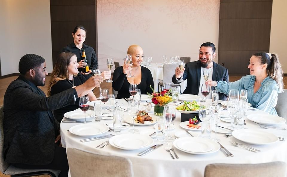 Guests at a finely set dining table in The Study at the University of Chicago