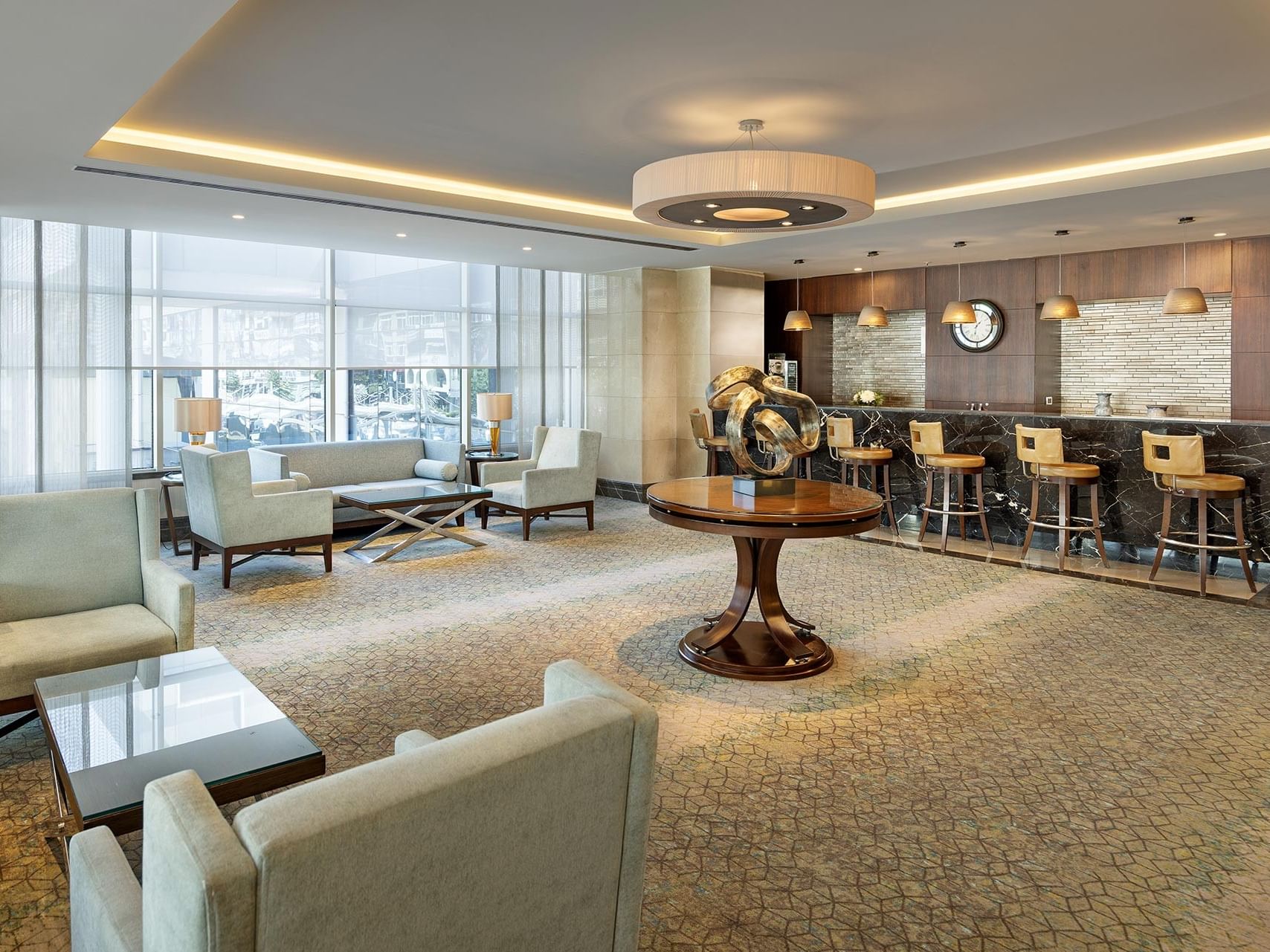 A1 katı fuaye alanında beyaz koltuklar, yuvarlak masa ve tabureler ile mermer tezgâhlı bar Titanic Port Bakırköy’de.