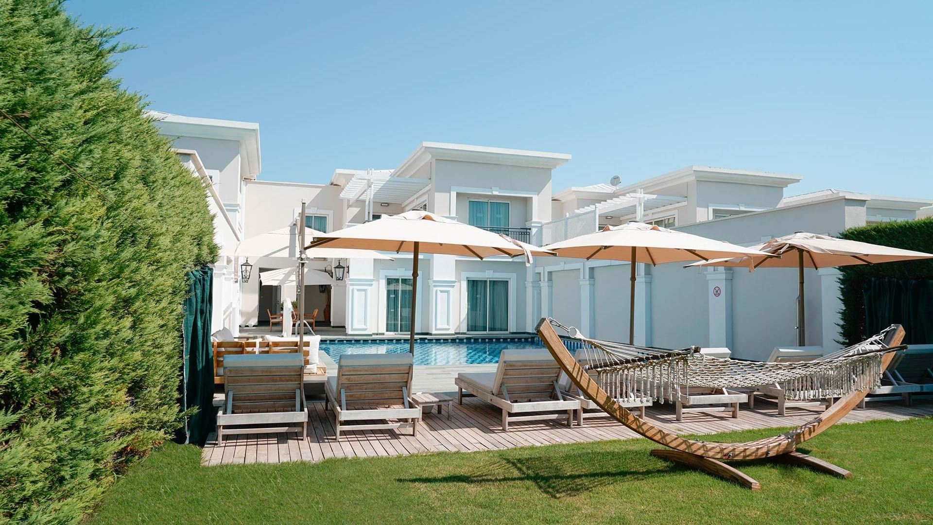 Сад виллы Superior в Titanic Deluxe Golf Belek — оазис покоя с уютным гамаком.