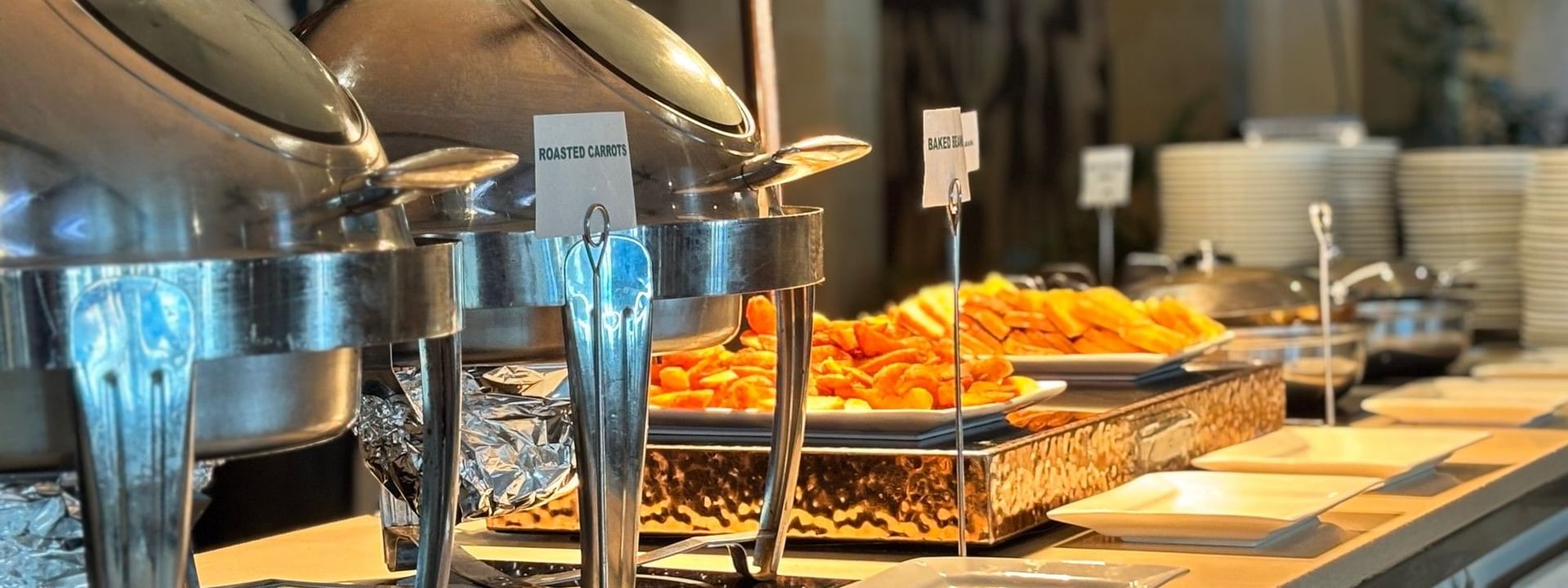 Buffet spread with various dishes and plates at Bula Brasserie in Korolevu at Warwick Fiji Resort and Spa
