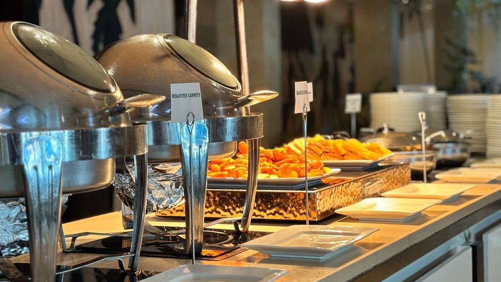 Buffet spread with various dishes and plates at Bula Brasserie in Korolevu at Warwick Fiji Resort and Spa.