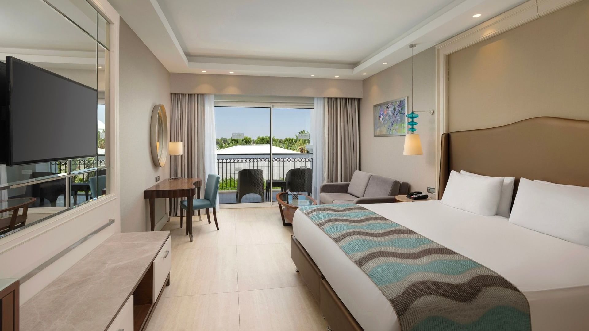 Family Pool Suite Balcony, geniş yatak, oturma alanı ve havuz manzaralı balkon, Titanic Deluxe Golf Belek'te