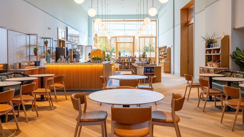 Contemporary café space with natural light, relaxed seating, and grab-and-go offerings.