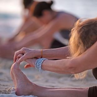 Women doing yoga on the beach at The Somerset on Grace Bay