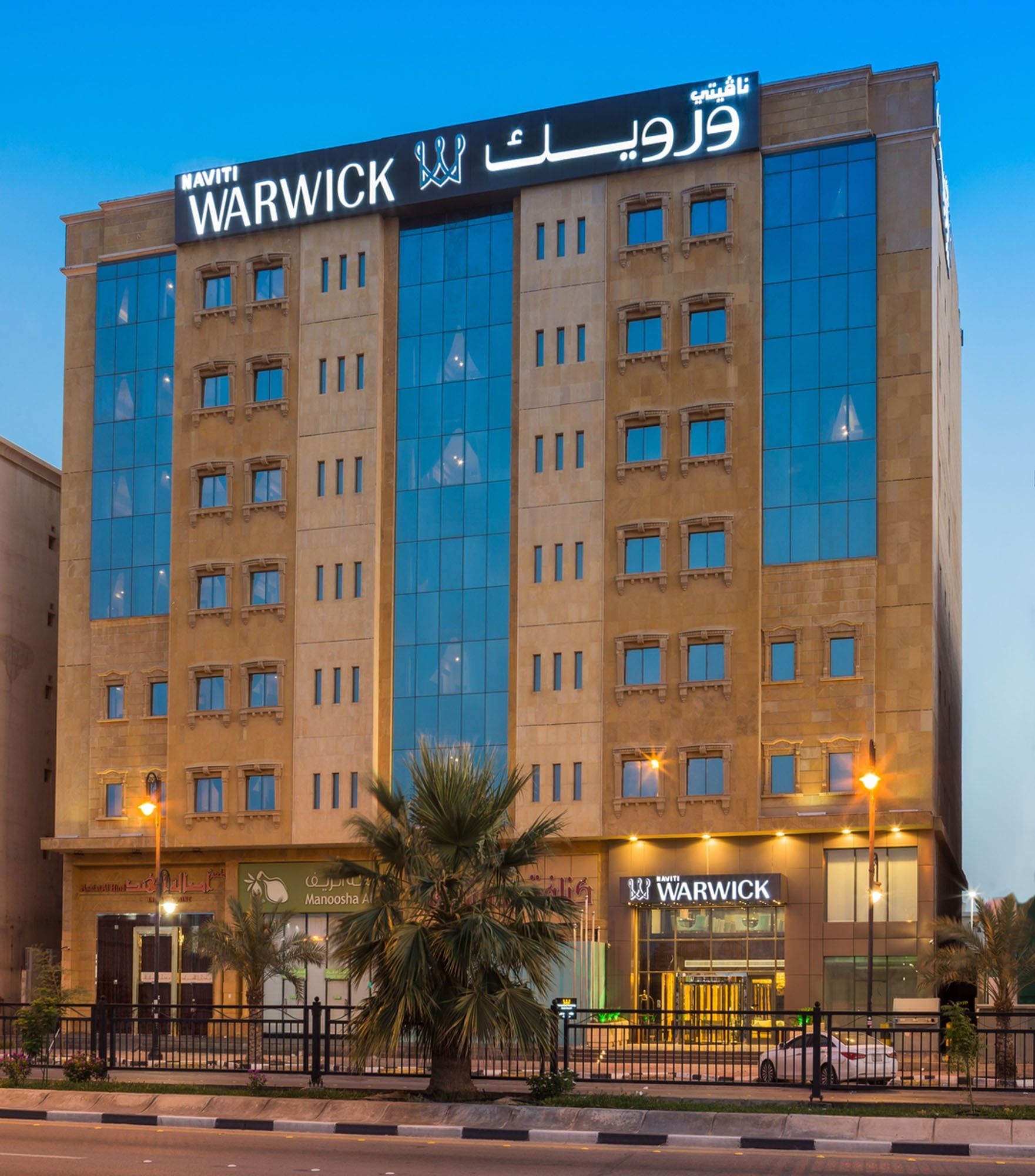 Exterior of Naviti By Warwick Dammam, featuring glass windows by street lamps under a blue sky