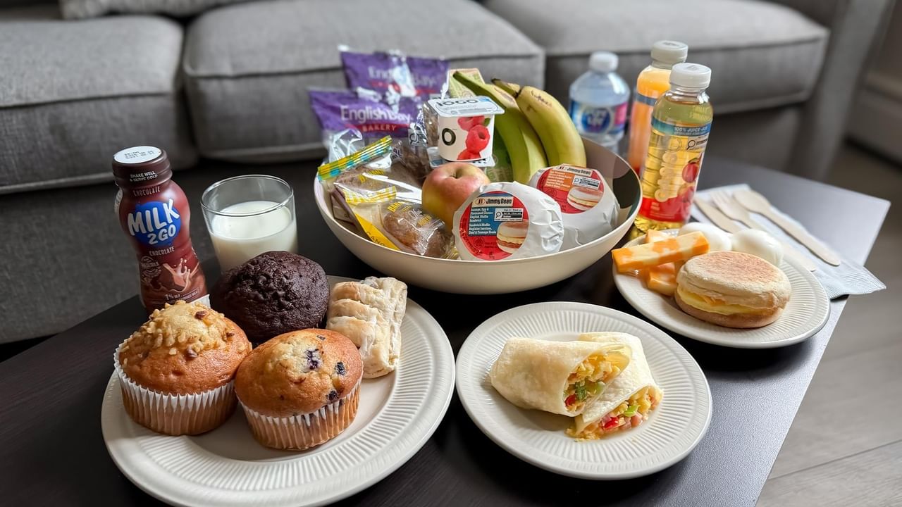 Plates of muffins, a wrap, and breakfast sandwiches.