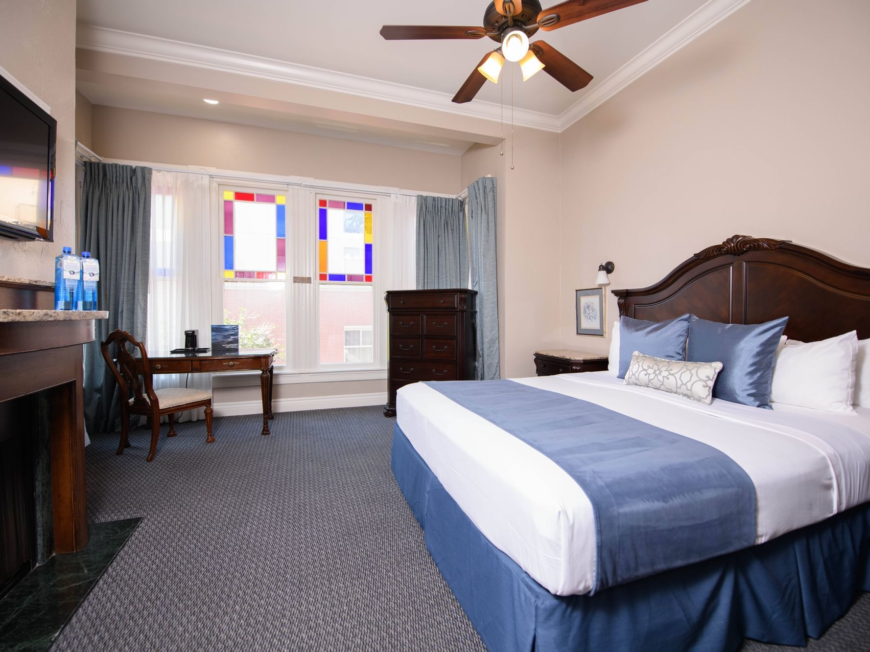 TV and workspace by the bed in 1 King Bed Room with Fireplace at Horton Grand Hotel