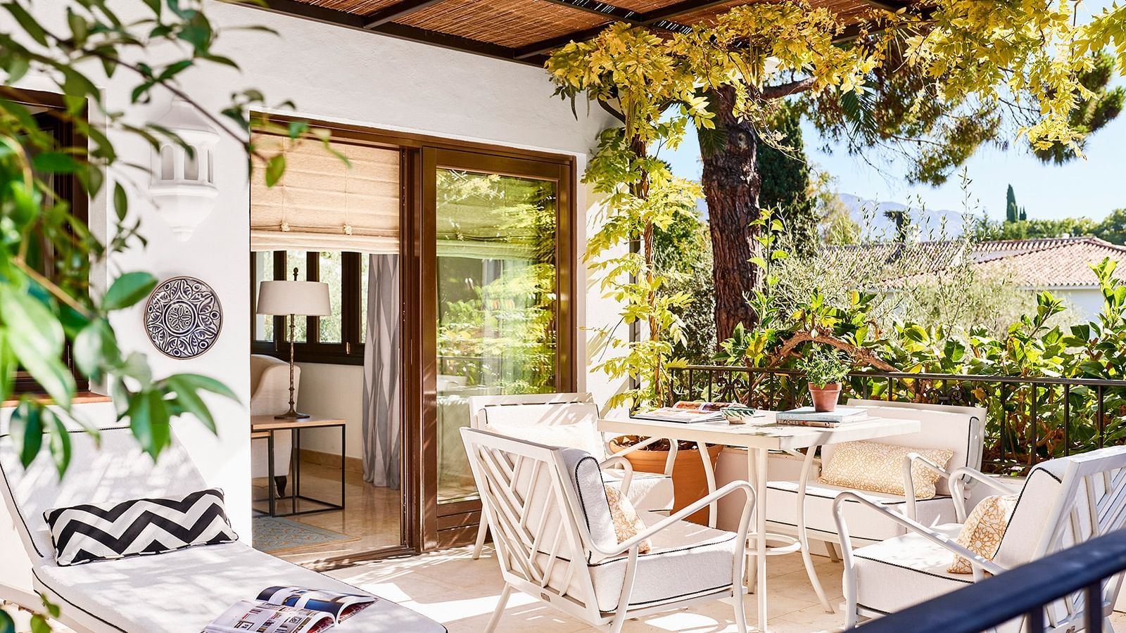 Conde Rudi private terrace with outdoor dining furniture & a view of the resort gardens at Marbella Club