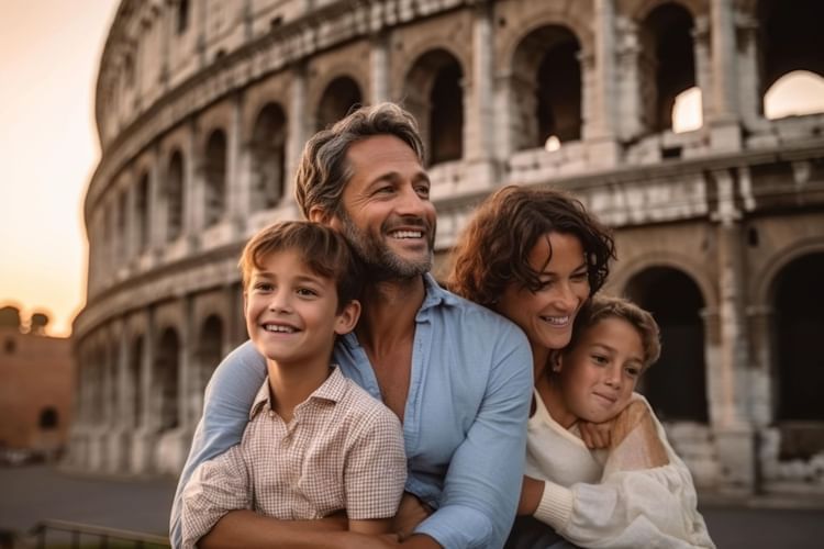 A family of four poses joyfully at sunset with the Colosseum in the background, near The Guardian Hotel