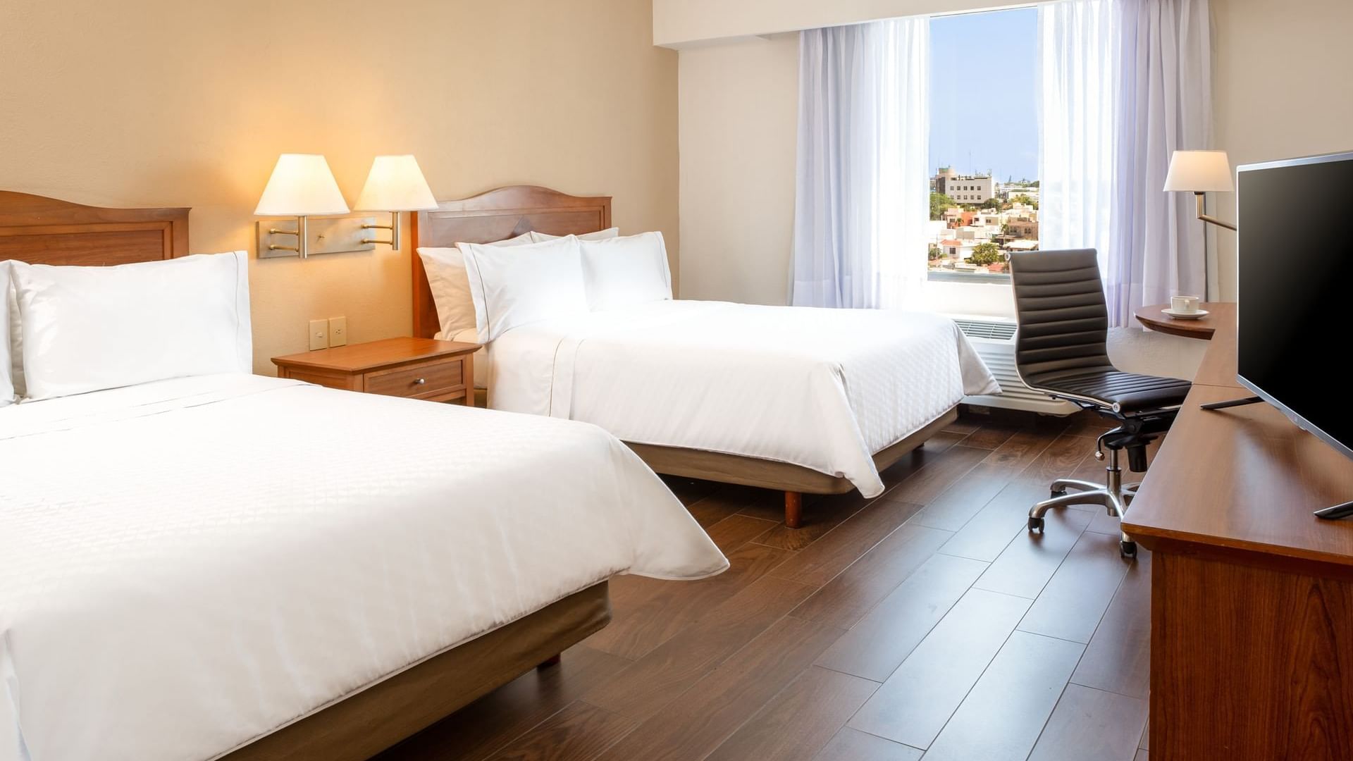 Twin beds & work desk in a guest room at Fiesta Inn Tampico
