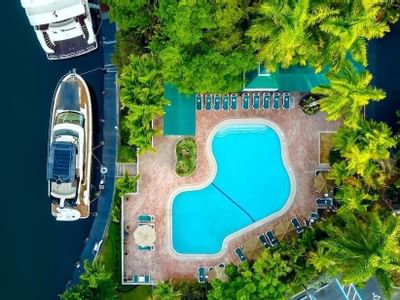 aerial view of outdoor pool overlooking river and boats