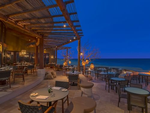 Restaurante De Cortez con mesas vacías y faroles con vista al mar al atardecer en Hacienda del Mar Los Cabos