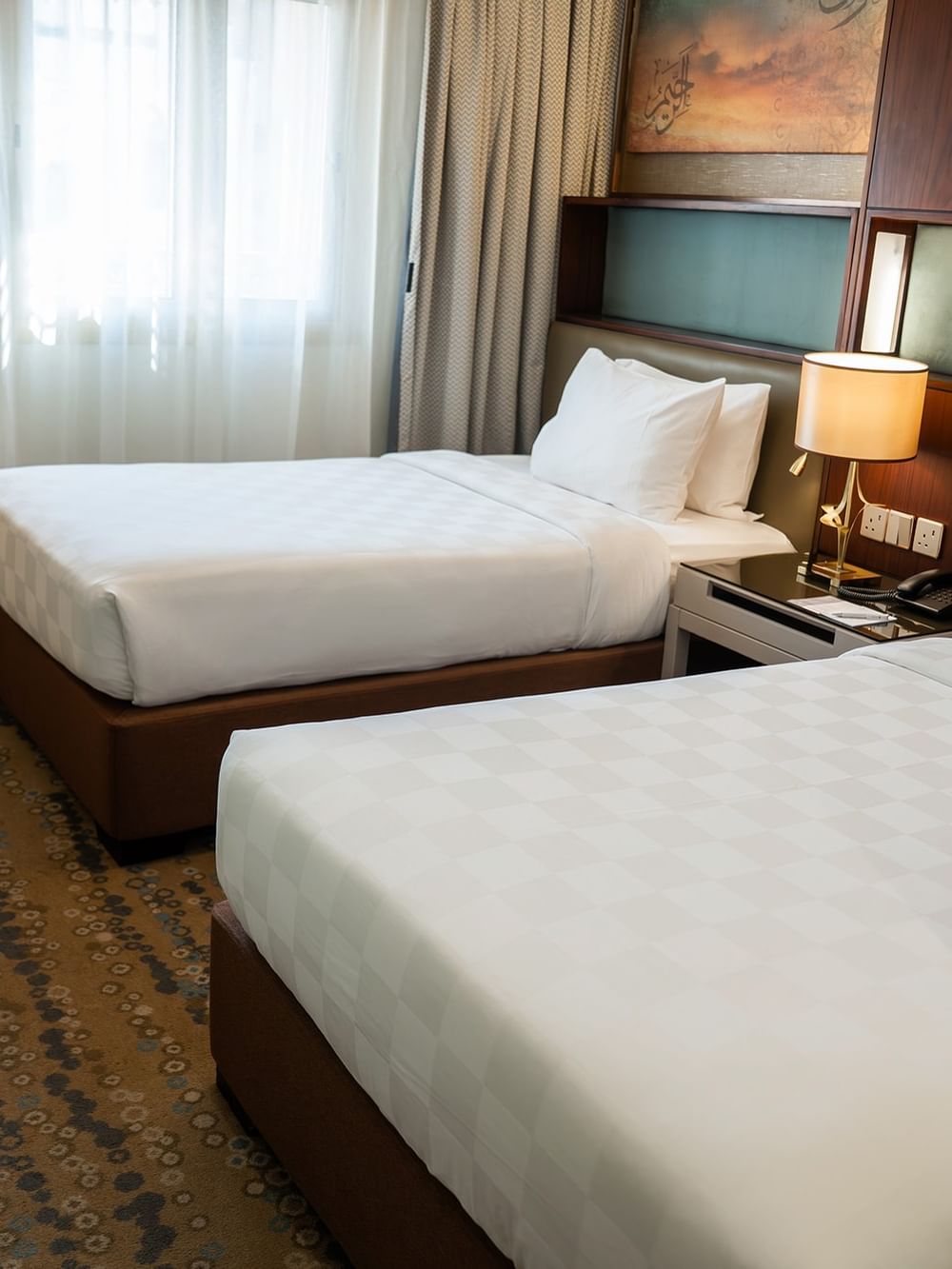 غرفة مزدوجة قياسية مزودة بسريرين ومصابيح ونافذة في فندق سجى ورويك المدينة المنورة.