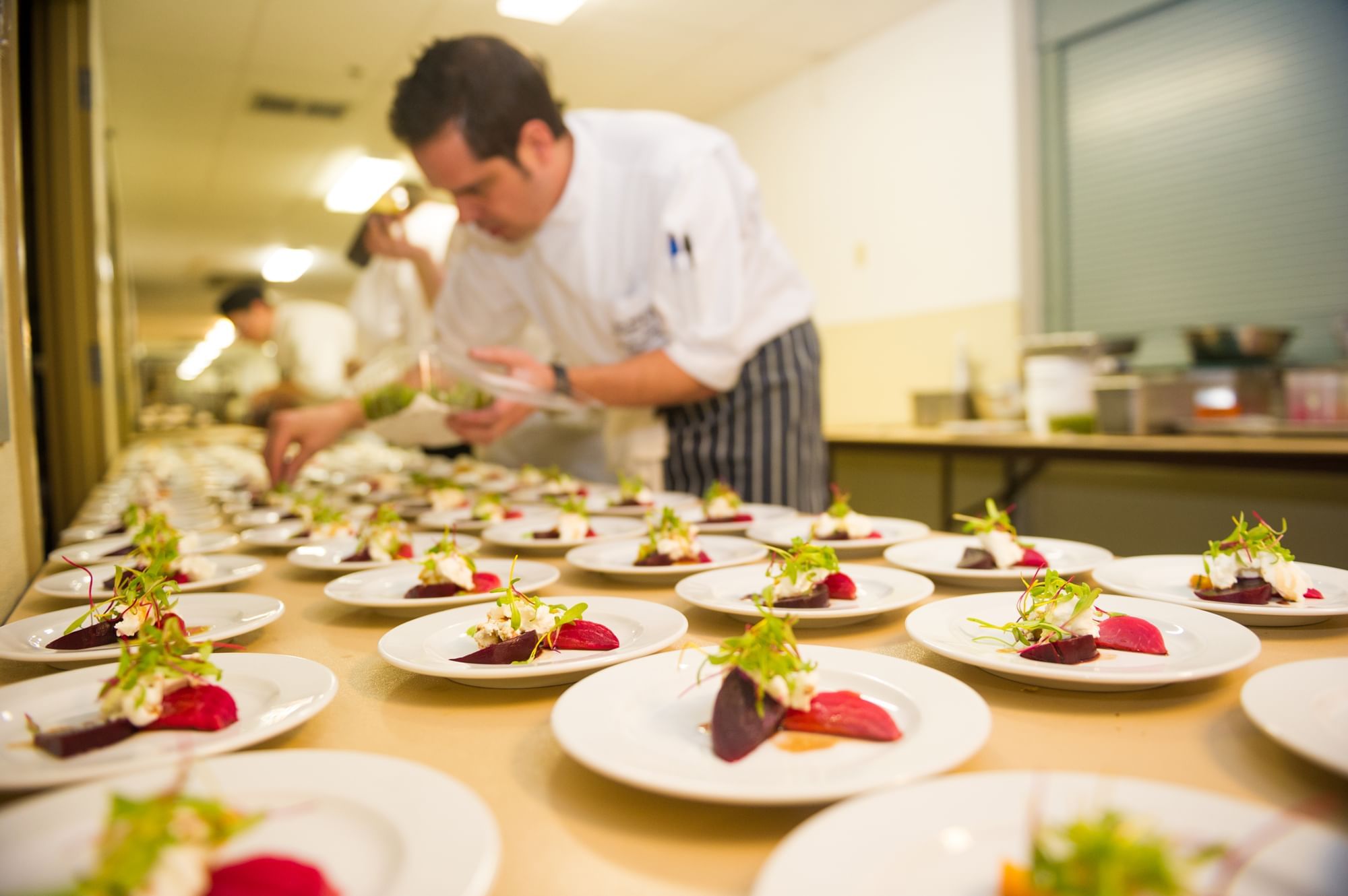 Chefs arranging plates of foods in Cornucopia Whistler near Blackcomb Springs Suites