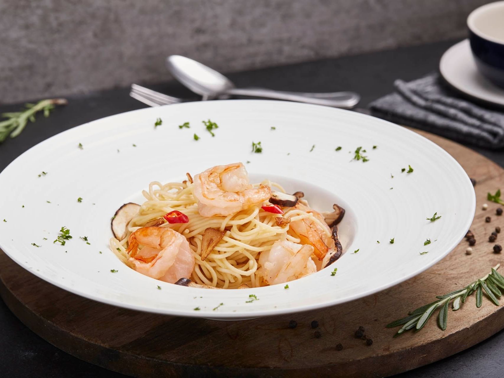 Vibrant Ala Carte Aglio Olio with parsley and chilli, served on a wooden board at Crystal Café, Orchard Grand Court