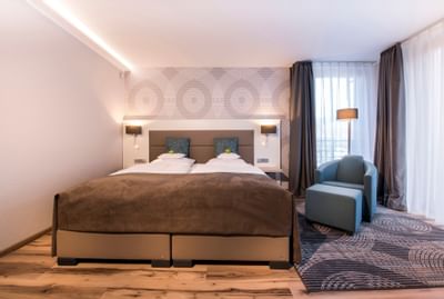 Doublebed with Sofa chair in Standard room in Hotel Collegium Leoninum, Bonn