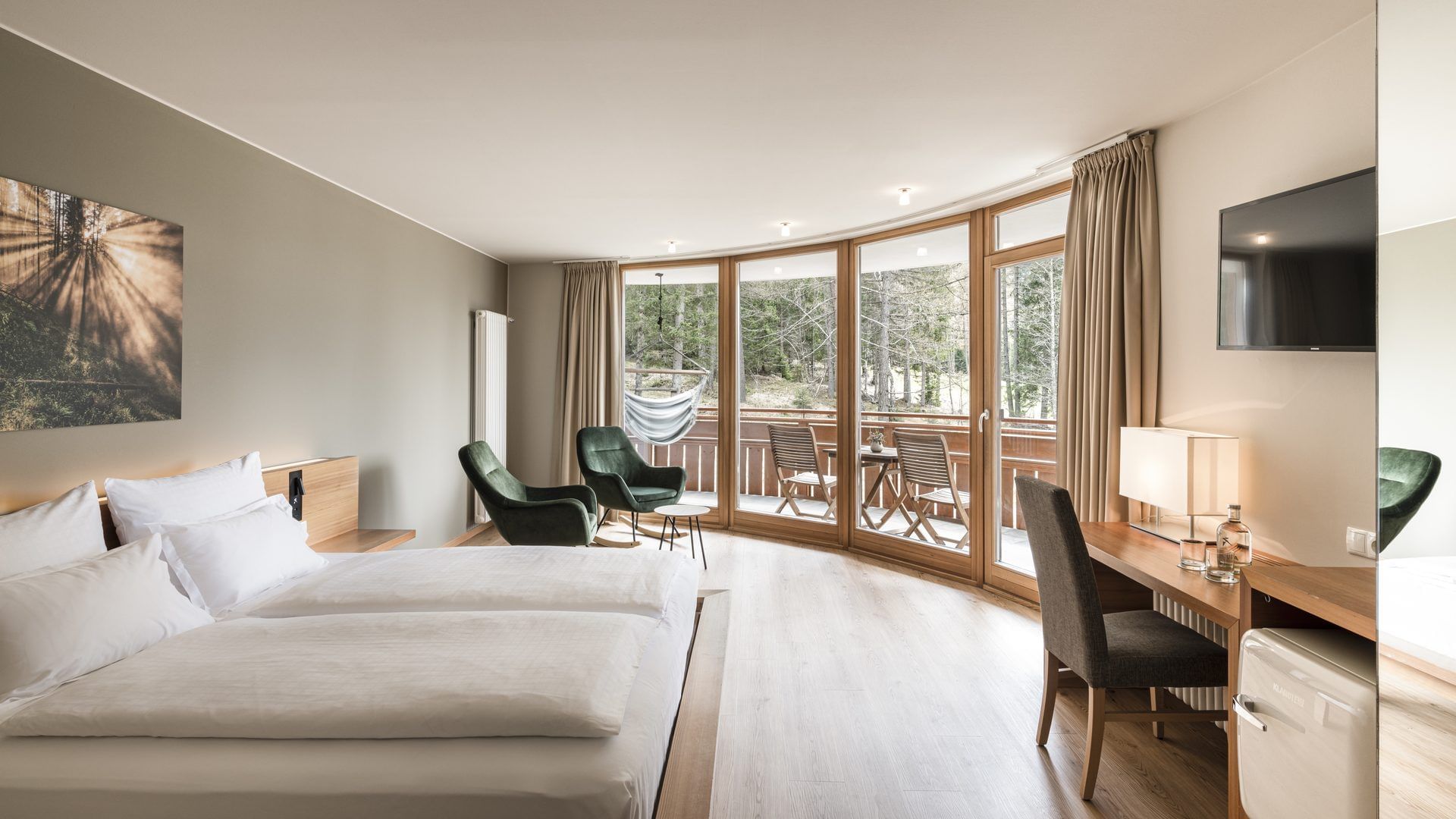 Bed, lounge & balcony in Panorama Suite at Falkensteiner Hotels