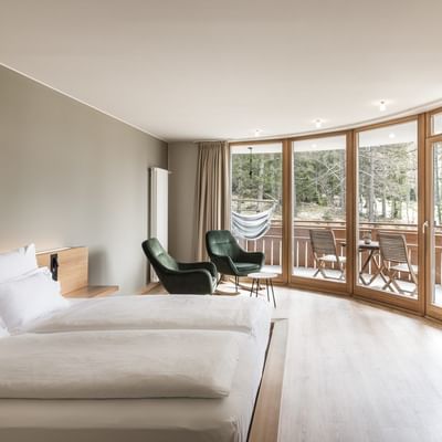 Bed, lounge & balcony in Panorama Suite at Falkensteiner Hotels