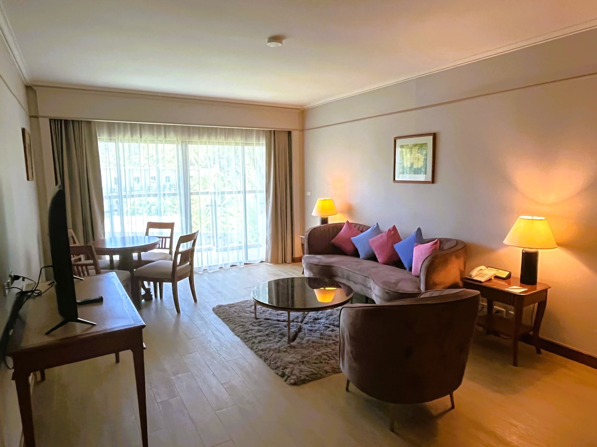 Tv lobby area with dining table in Casuarina Suite at Amora Hotel Beach Resort Phuket