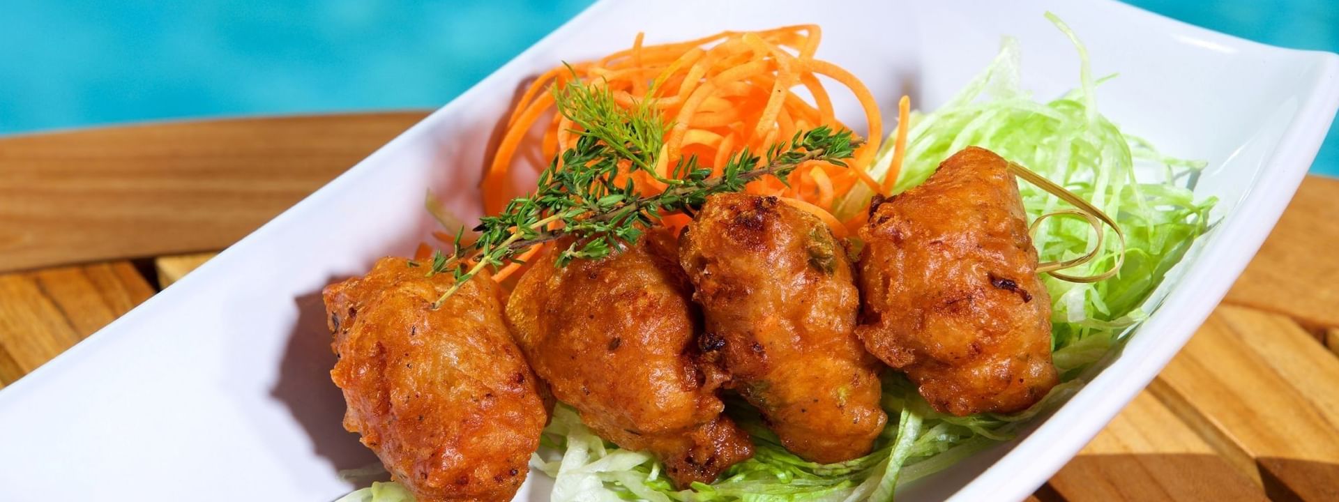 Crispy fritters with a sauce under a herb sprig in Chickcharnie's Pizzeria & Grille at Warwick Paradise Island Bahamas