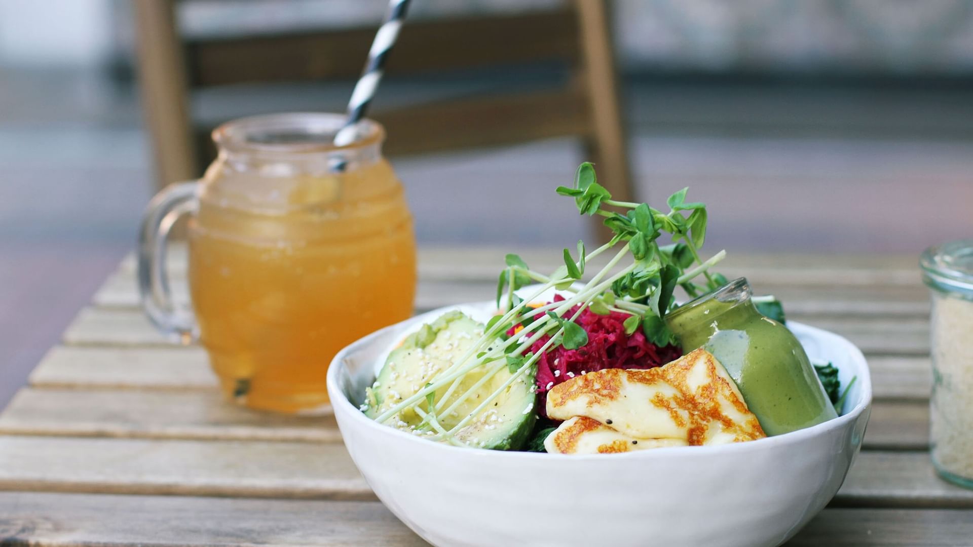 Healthy salad bowl with fresh avocado by a cold iced tea glass in Girdlers Café at Elysium Manly, a featured hotel in Manly