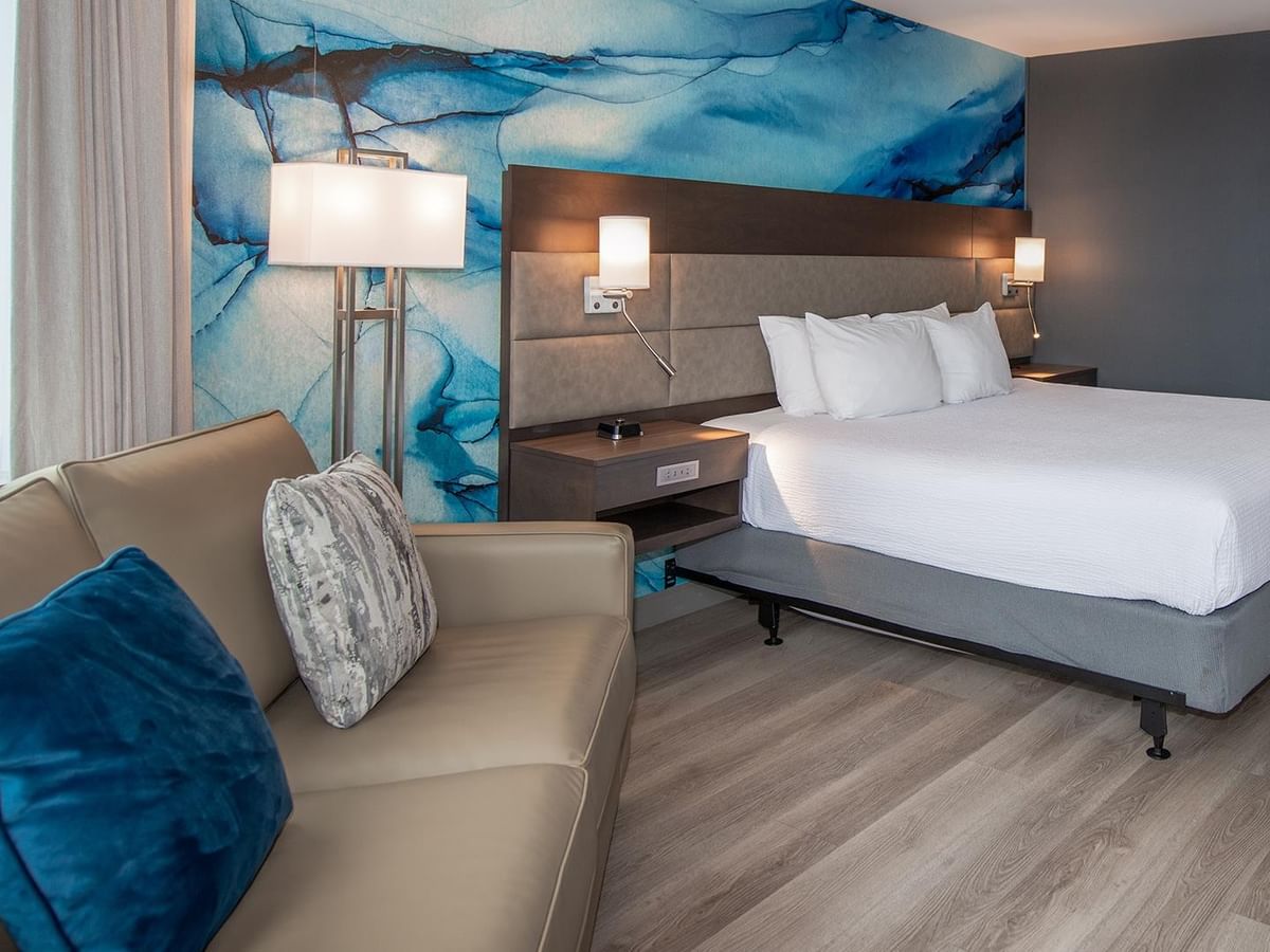 A comfy bedroom with a king bed and a sofa at Coast Bastion Hotel in Nanaimo.