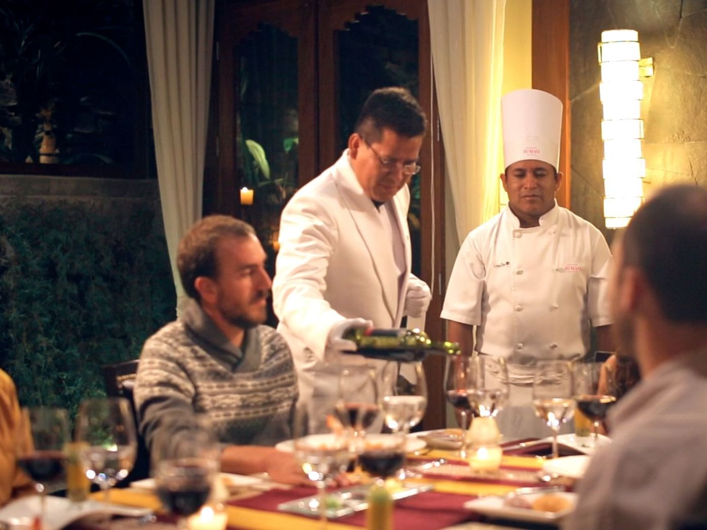 A waiter poring red wine in Private dining room at Hotel Sumaq