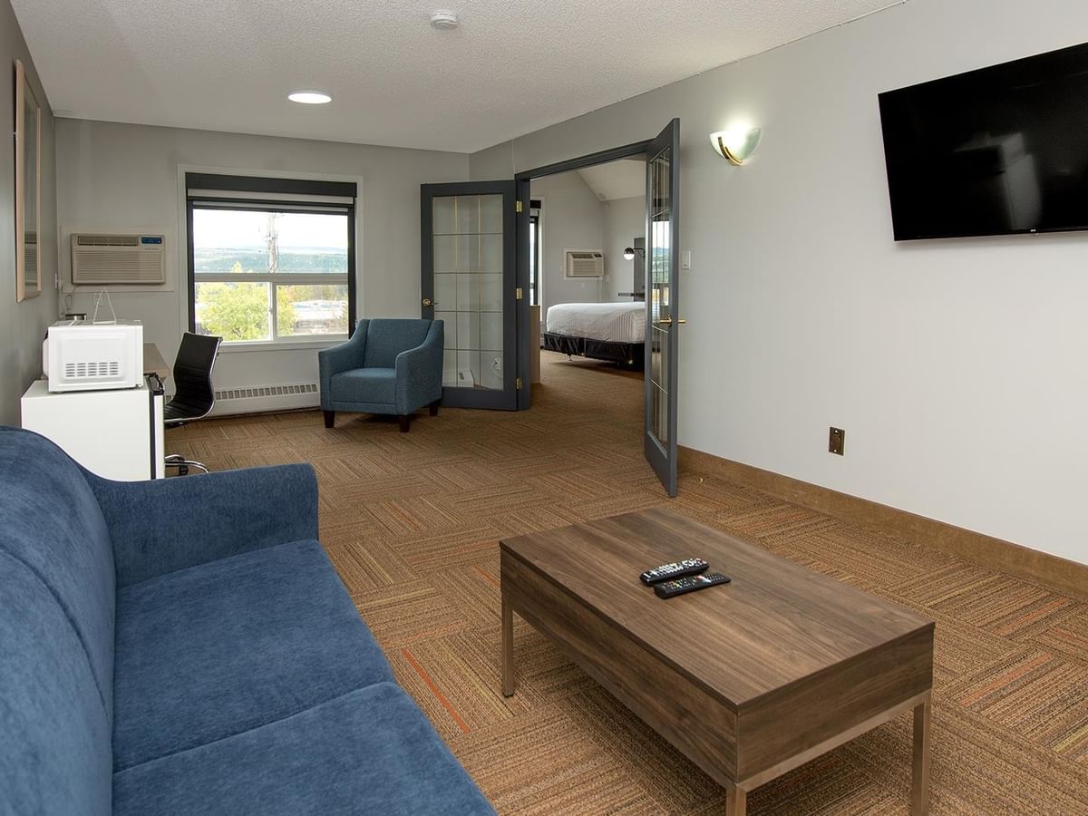 Coast Suite with blue sofa, coffee table, armchair and separate bedroom.