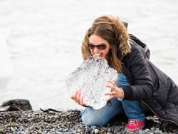 Woman tasting a piece of ice at the lake near Hoteles Australis