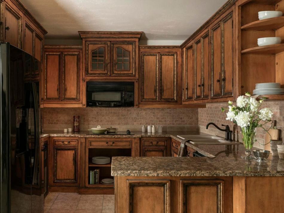 Presidential Suite, kitchenette with wooden cabinets and granite countertops at Granduca Houston