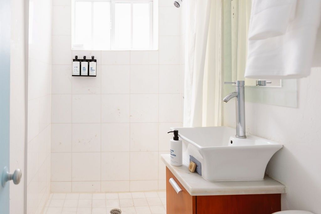 A clean bathroom with a shower, sink, and mirror.