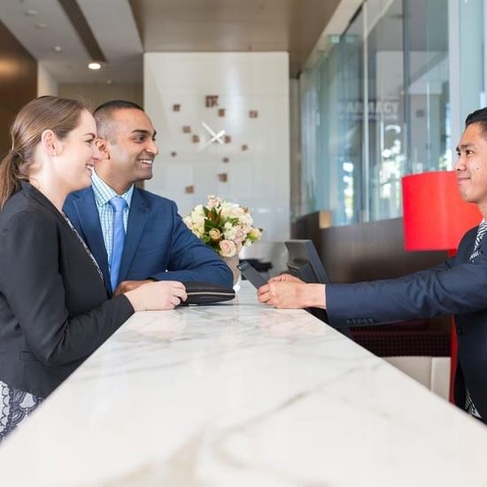 Couple checking in by the front desk at Pullman Olympic Park