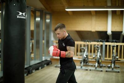 A man hitting a punching bag in a gym at Liebes Rot Flueh