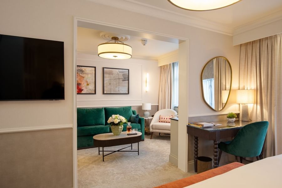 Bed with work desk set by doorway leading to living area at The Capital Hotel, Apartments and Townhouse